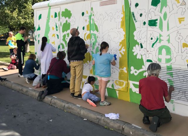 Mayores y pequeños pintan un gran mural en el parque de la Constitución